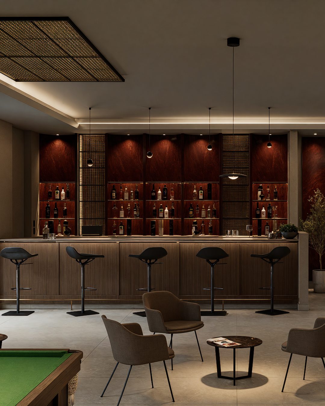 Detalle de bar con barra de madera, bancos altos y contrabarra iluminada en tono vino